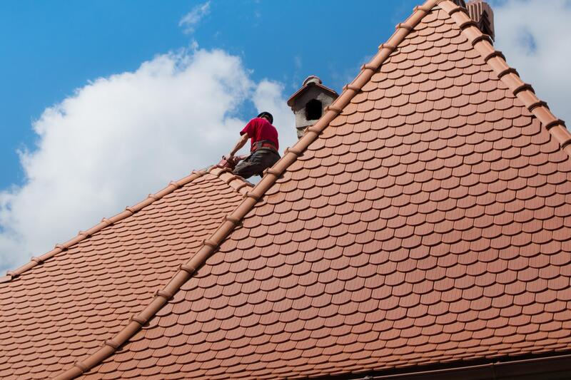 professional roofer working on house roof replacement 