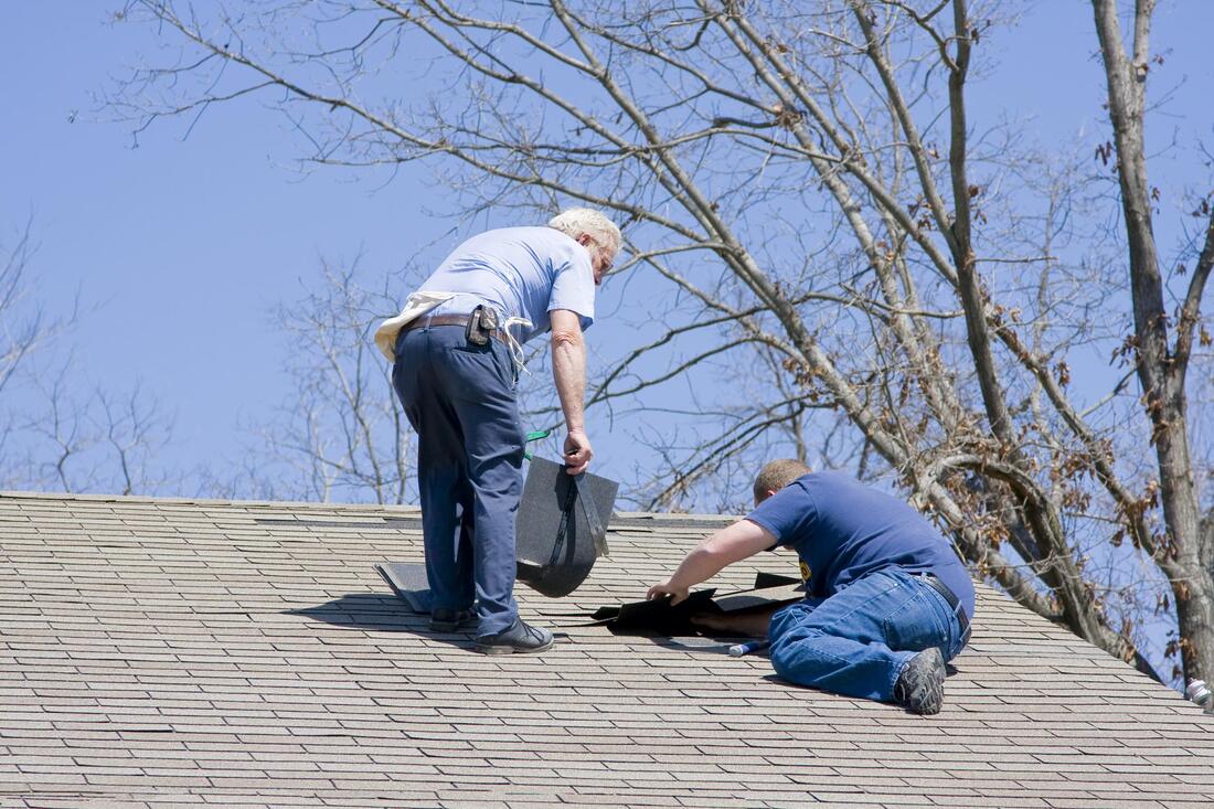 professional roofer working on house roofing 